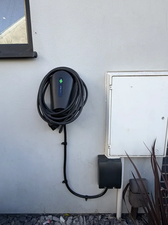 EV charge point, coiled lead and isolator installed on a house wall in Cardiff
